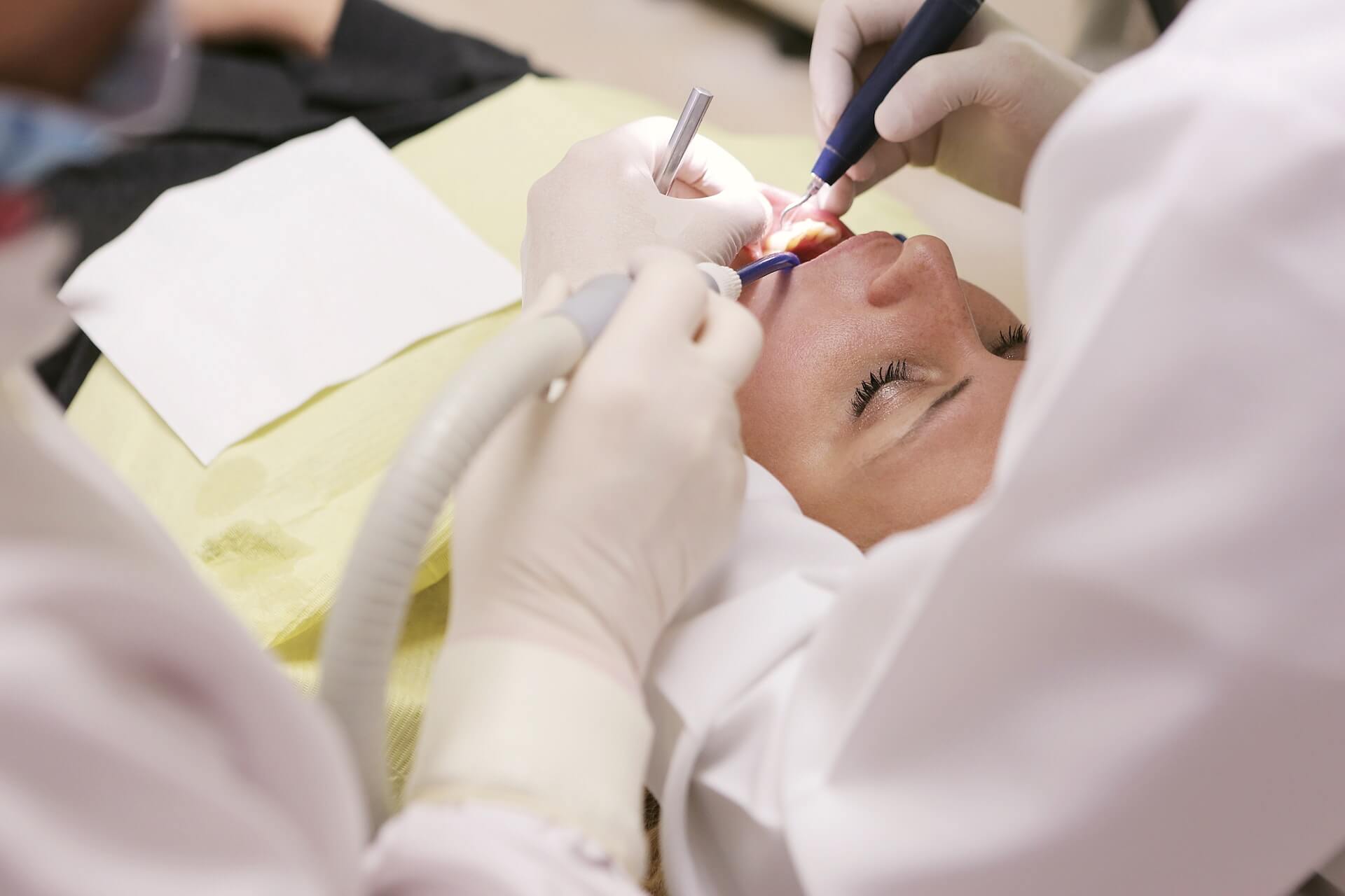 A dentist performs oral surgery on a patient.