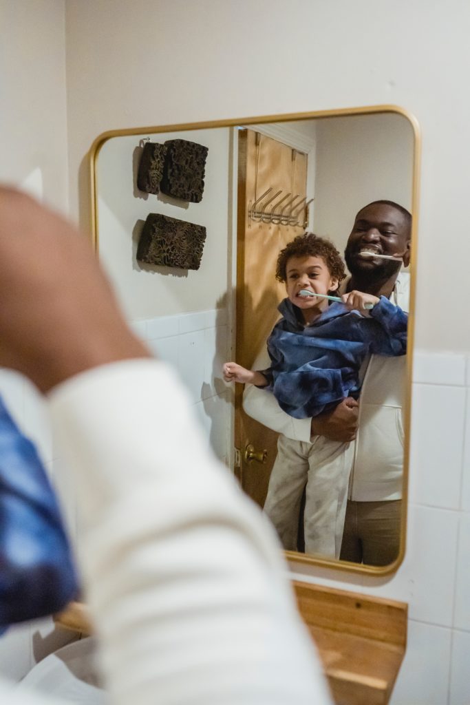 A father and son brushing their teeth and gums