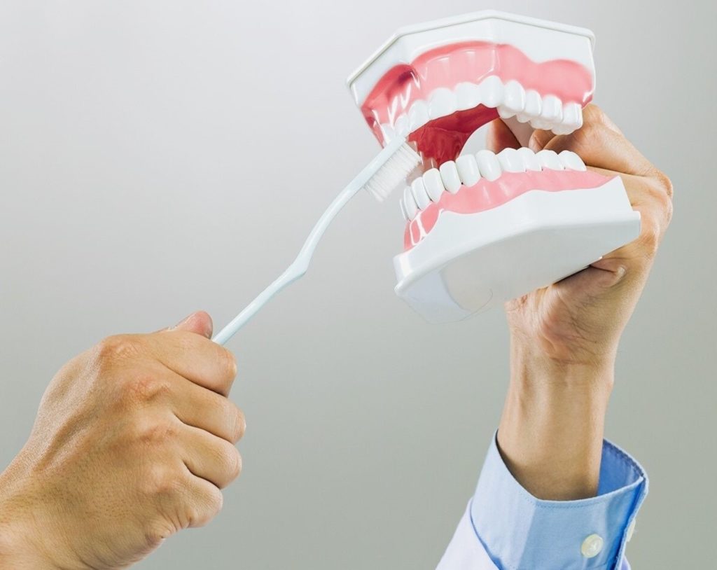 A person brushing dentures 