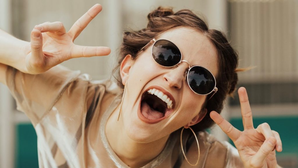 Woman smiling while wearing sunglasses