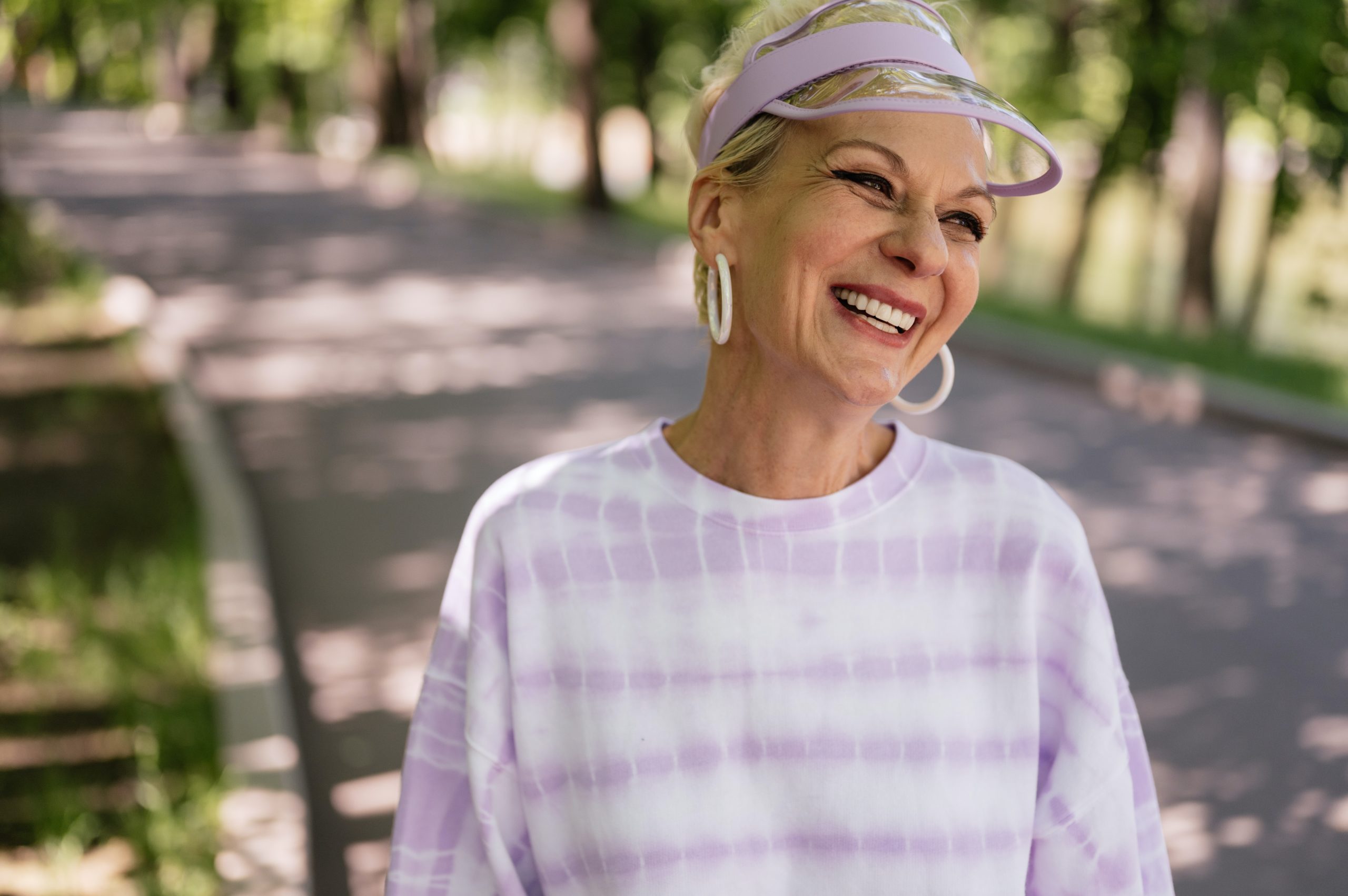 A woman with dentures smiling outdoors